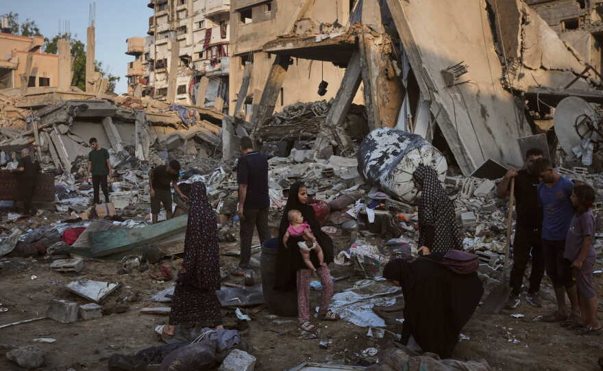 Palestinians salvage their belongings from the rubble of a building and tents destroyed in an Israeli airstrike in Gaza City, Thursday, July 30, 2026.