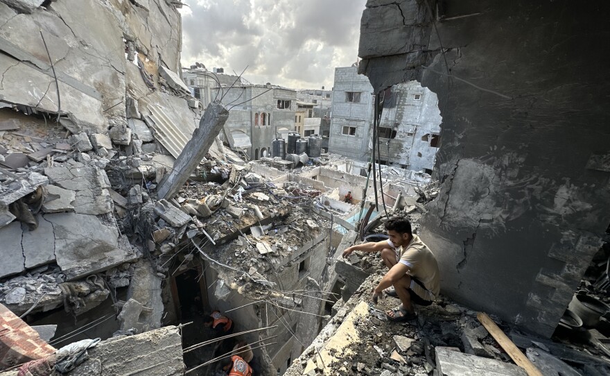 Rescue workers search under the rubble of a building in Rafah outside the evacuation zone that was hit by an Israeli airstrike on Tuesday. Health officials in Gaza say at least 13 people from one family were killed in that attack.