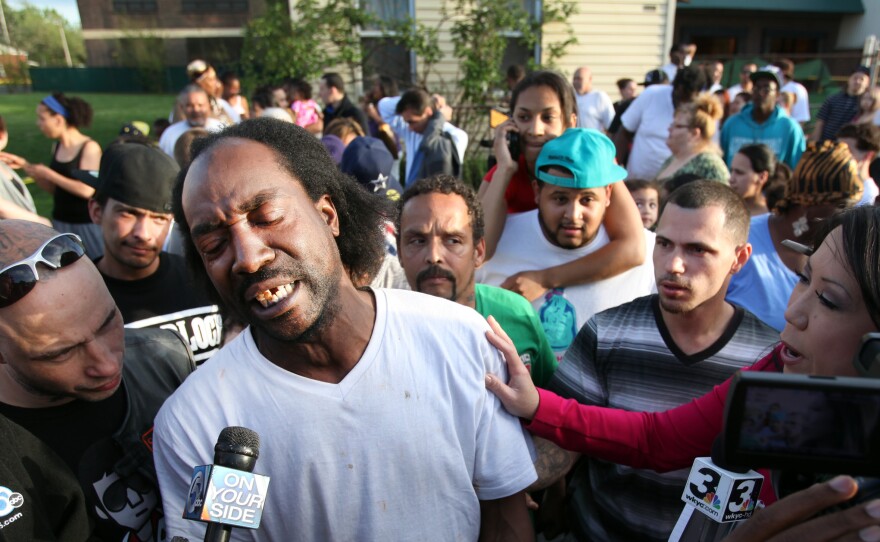 Charles Ramsey talks to media as people congratulate him on helping some women get out of a home in the 2200 block of Seymour Ave on Tuesday. Amanda Berry, Gina DeJesus and others were rescued from the house.