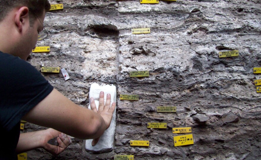 Christopher Miller samples sediments from an excavation site in South Africa. Archaeologists found layers upon layers of burned bedding material, indicating that the hunter-gatherers who lived here 77,000 years ago stayed for a long time.