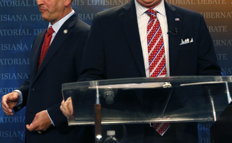 Louisiana Democratic state Rep. John Bel Edwards walks past Republican U.S. Sen. David Vitter as they take their places before a gubernatorial debate.