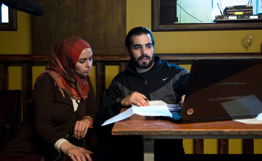 Mona, left, sits next to Syrian playwright Mohammad al-Attar as he gives her some instructions during rehearsal.