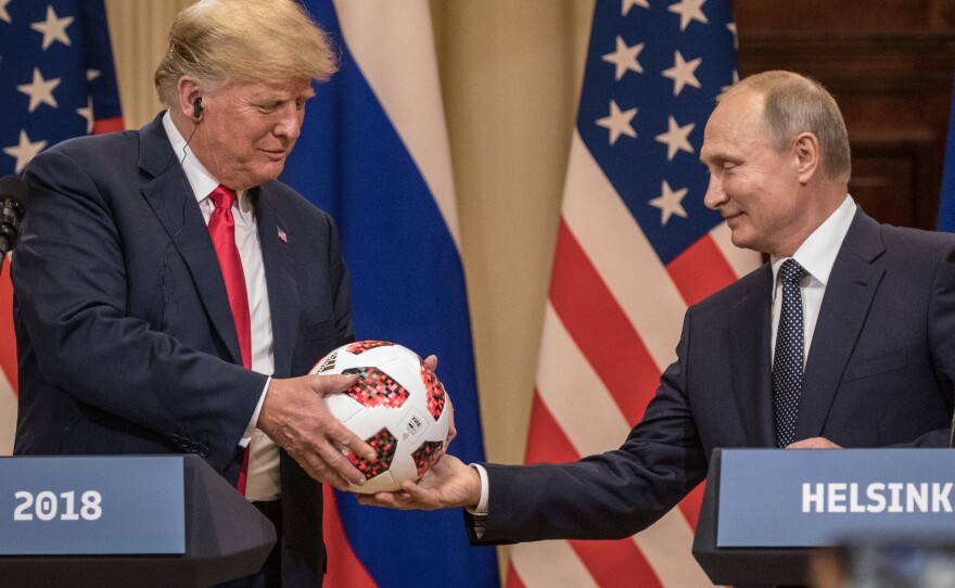 Russian President Vladimir Putin hands then-President Donald Trump a World Cup football during a joint press conference after their summit on July 16, 2018 in Helsinki, Finland.