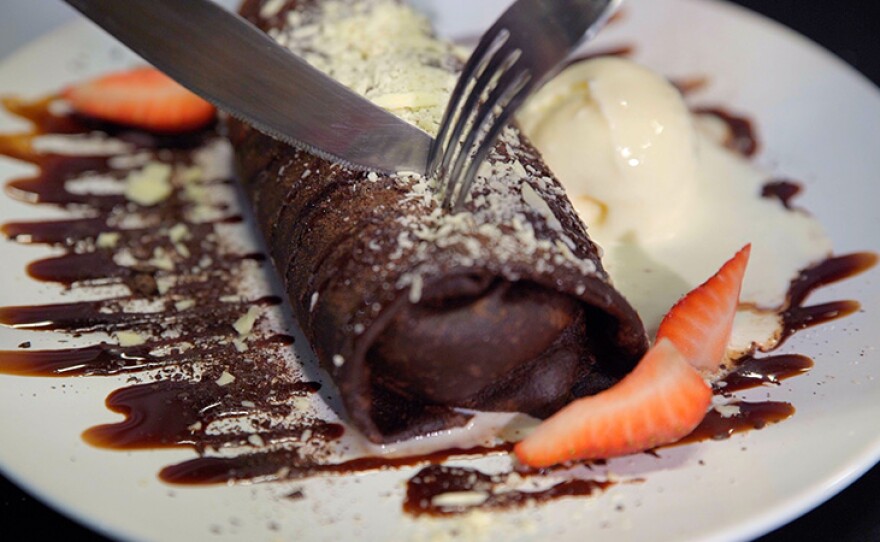 Host Jorge Meraz cuts into a chocolate-nuttela-mousse-banana crepe at Creperia Polanco in Tijuana, Mexico.