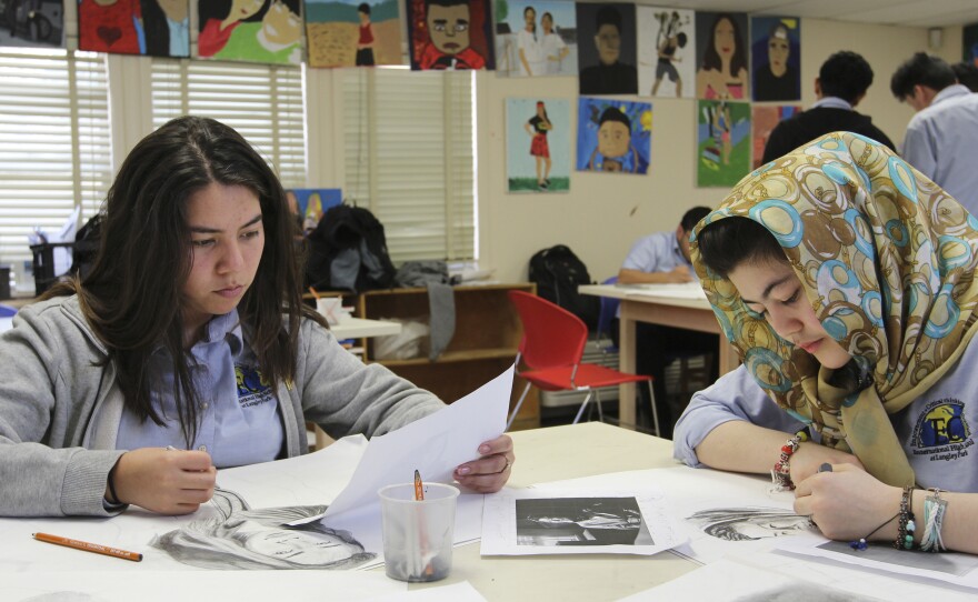 Two talented young artists — Stefany Novoa (left), 16, and Frishta Wassl, 14 — work on self-portraits in Christine Wilkin's art class.