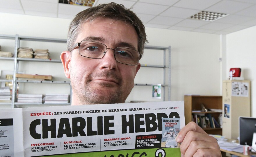 Stephane Charbonnier, the editor of Charlie Hebdo, poses with his magazine on Sept. 19, 2012. The magazine, which was attacked today, is part of a long tradition of French satire.