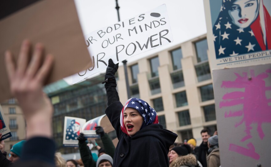 A woman wearing an American flag as a headscarf attends a protest for women's rights and freedom in solidarity with the Women's March on Washington in front of Brandenburger Tor in Berlin, Germany.