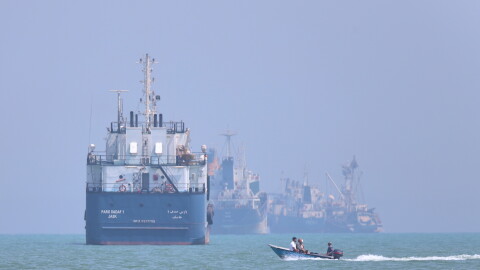 A small motorboat passes anchored vessels in the Strait of Hormuz off Bandar Abbas, Iran, Thursday, June 11, 2026.
