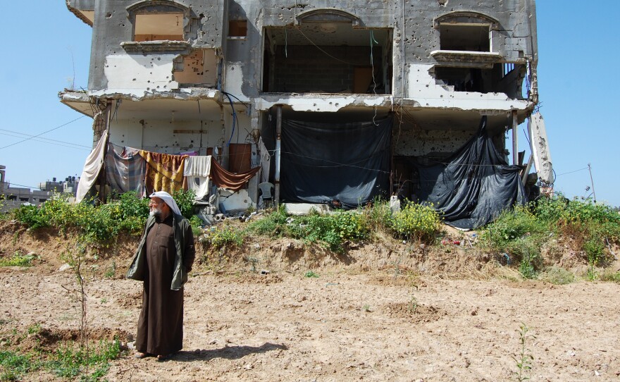 Hassan Faraj in the backyard of his damaged home in Gaza City. The 11 family members moved back in four months ago, though it's still not clear when the family will receive money to repair the damage.