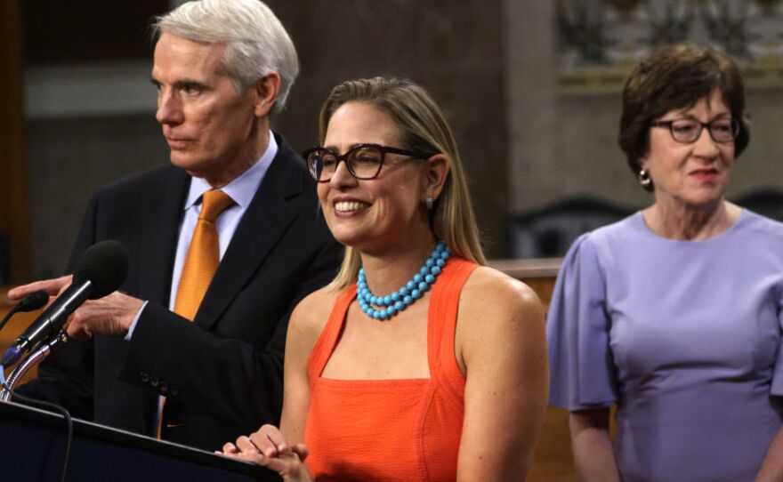 Sen. Rob Portman, R-Ohio (left) and Sen. Kyrsten Sinema, D-Ariz., answer questions from the press as Sen. Susan Collins, R-Maine, looks on during a news conference about the bipartisan infrastructure deal on July 28.