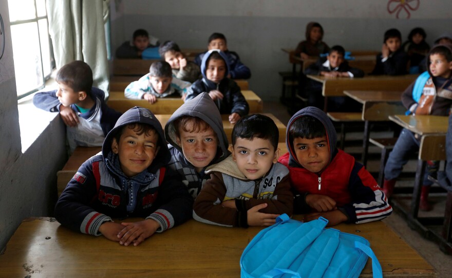Schoolchildren pose for a photo in a classroom at the al-Kufa school in Mosul.