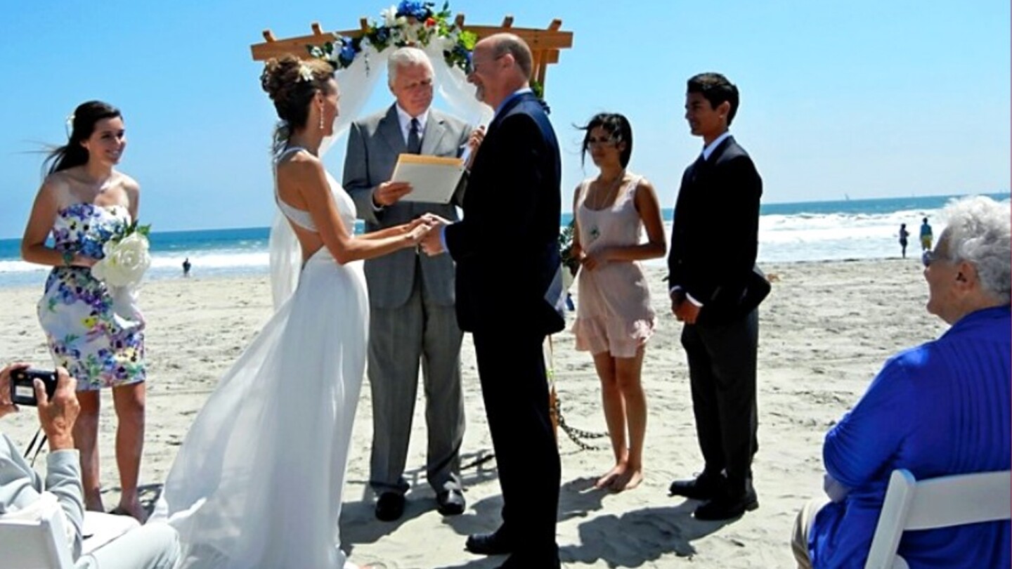 From glitch to love: Our eHarmony journey (Lori Mitchell and Dan Dredla) I had been divorced for several years, had raised my daughter and was ready to date. So, I filled out my eHarmony profile and waited for my perfect computer match. I was in my 40s, living here in San Diego. I wanted someone no more than an hour away and no older than ten years older than myself. My "perfect" match came in. He was a 60-year-old hay loader from Nevada. He mentioned that the one thing he could not live without was "gambleing, boling and sex." Yes, the ONE thing was three things and he spelled "bowling" and "gambling" incorrectly. I tried to keep an open mind, but this just didn't seem right. I called eHarmony, and they let me know there had been a glitch in the system and asked me to resubmit my answers. The first reply I got was from Dan. He was my age, just 30 minutes away, and had the most beautiful eyes. We met, talked and I just felt at home on our first date. About a year and a half later, he proposed at Buon Appetito in Little Italy, where we had our first dinner date. I was so taken that I forgot my purse in the restaurant, but the waiter brought it right out to me on the sidewalk. We got married right next to Dog Beach in Coronado. We love dogs, but our cats do not, so we get our dog fix at the dog beaches. We will be celebrating our 14th anniversary this May, and all is good. This photo is from our wedding. My daughter, April, is by me, and Dan's son, Eric, and daughter, Jen, are by his side. They all get along great.