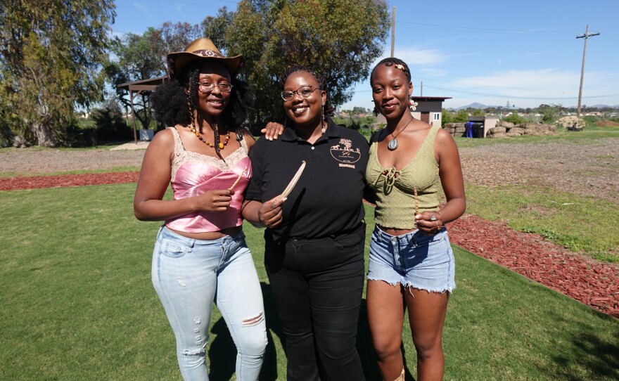 Jazzay Buncom, Diamond Brandon and Lucie Cishugi (left to right) hold red burgundy okra and black-eyed pea seeds at S&S Friendly Ranch on Feb. 27, 2026.