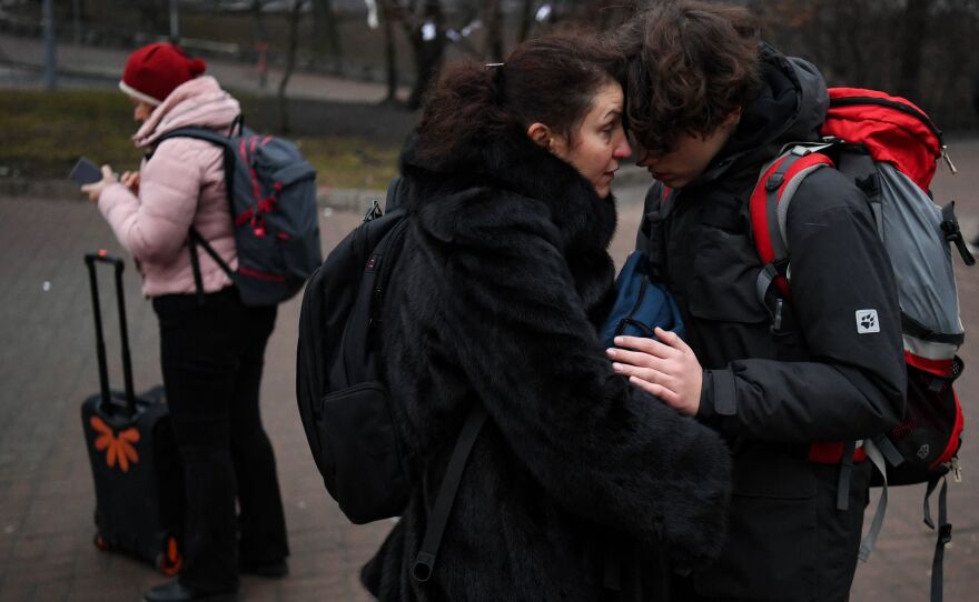 People hug outside a metro station in Kyiv on Thursday morning as Russia launched an attack on Ukraine and explosions could be heard in the city.