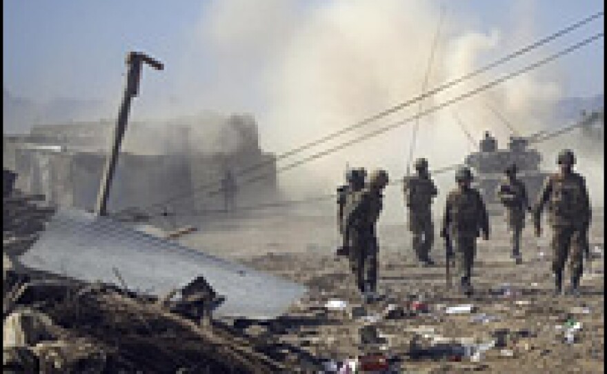 Pakistani soldiers walk past damaged houses in Loisam, in the Bajaur tribal region, in October.