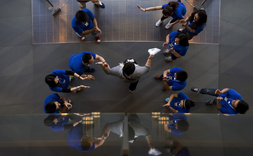 Apple says it has sold 9 million iPhone 5s and 5c models since their launch on Friday. Here, staff at an Apple retail store in Beijing cheer a customer after he bought a new iPhone.