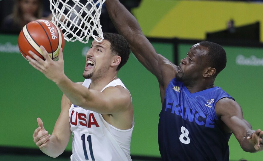 United States' Klay Thompson avoids France's Charles Kahudi for a layup Sunday. The U.S. won their third straight close game, 100-97, as Thompson led the way with 30 points.