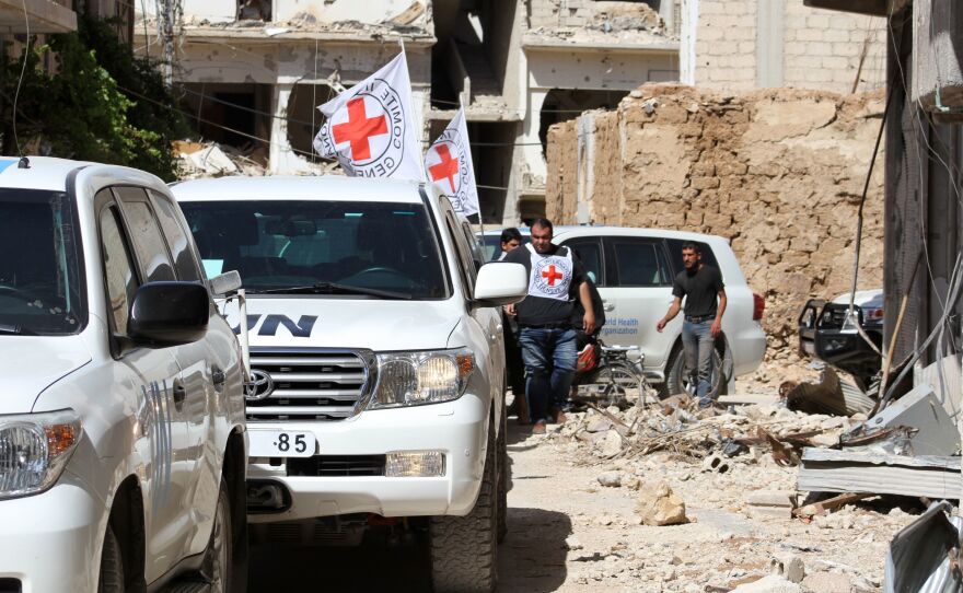 Vehicles of the International Committee of the Red Cross and the United Nations wait after an aid convoy entered the rebel-held town of Daraya, near Damascus, on June 1. It was the first such delivery since a government siege began in 2012, the Red Cross said. But the opposition said only medical supplies were in the delivery, not desperately needed food.