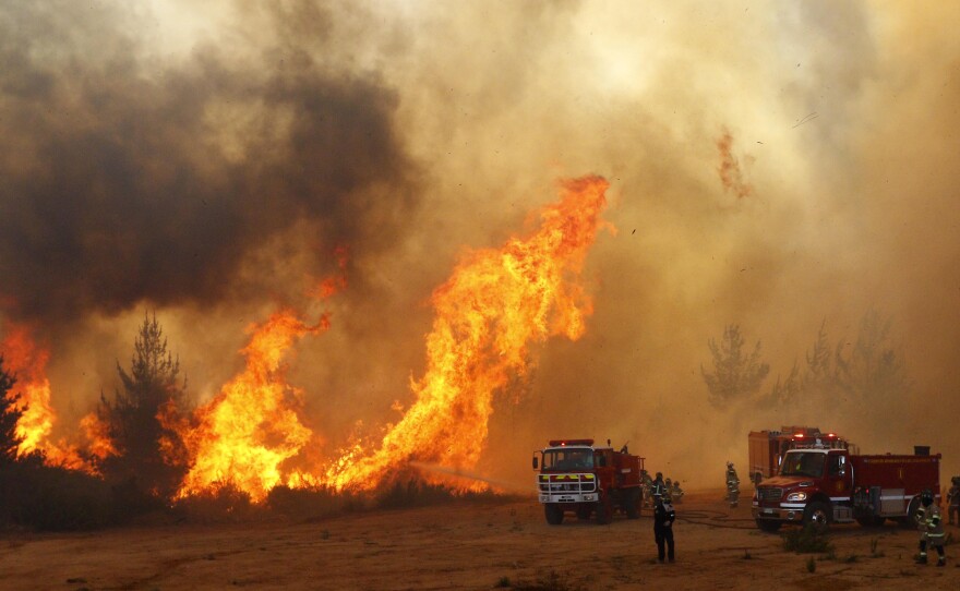 Firefighters work to put out a forest fire in Valparaiso, Chile, in March.