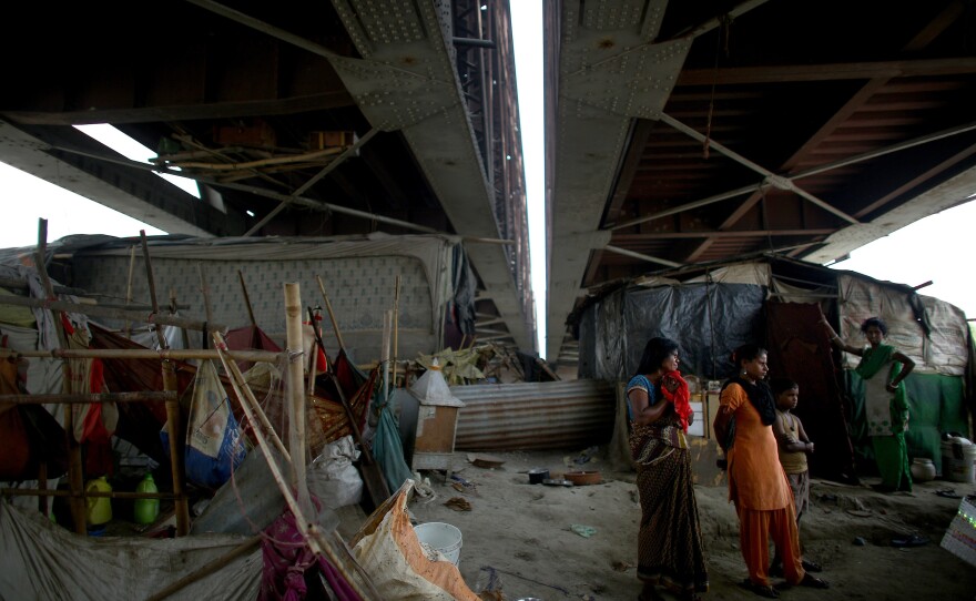 Women bathe, cook and raise their children along the banks of the highly polluted Yamuna River. Entire families take up residence beneath the Old Iron Bridge that crosses the river; they are forced to move to higher ground during the monsoons, when the river floods.