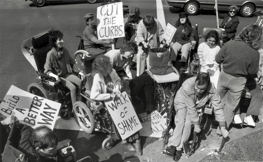 ADAPT activists smash sidewalk curbs to create curb cuts.