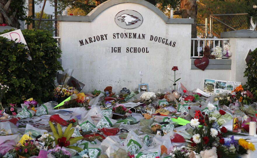 Flowers, candles and mementos sit outside one of the makeshift memorials at Marjory Stoneman Douglas High School in Parkland, Florida just days after the deadly shooting in 2018.