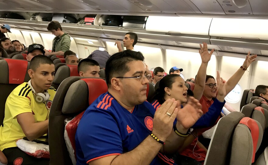 Soccer fans traveling from South America cheer after boarding a connecting red-eye flight from Madrid to Moscow.