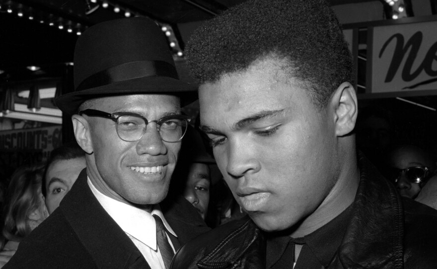 Muhammad Ali (right) is shown with Malcolm X, outside the Trans-Lux Newsreel Theater in New York City, after watching a screening of films on Ali's title fight with Sonny Liston on March 1, 1964.