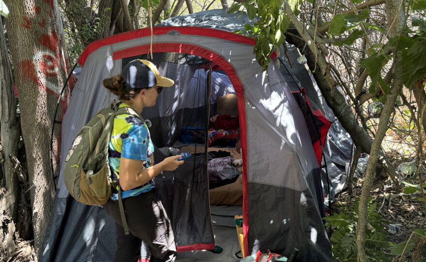 San Diego Riverpark Foundation COO Sarah Hutmacher checks in on a woman experiencing homelessness along the San Diego Riverbed on June 17, 2026.