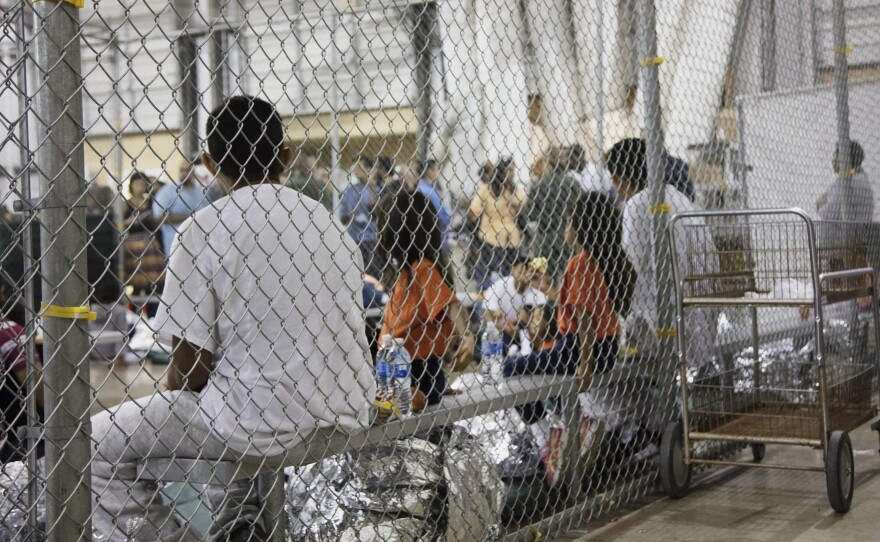 In this June 17, 2018 file photo provided by U.S. Customs and Border Protection, people who've been taken into custody on charges of illegal entry sit in cages at a facility in McAllen, Texas.