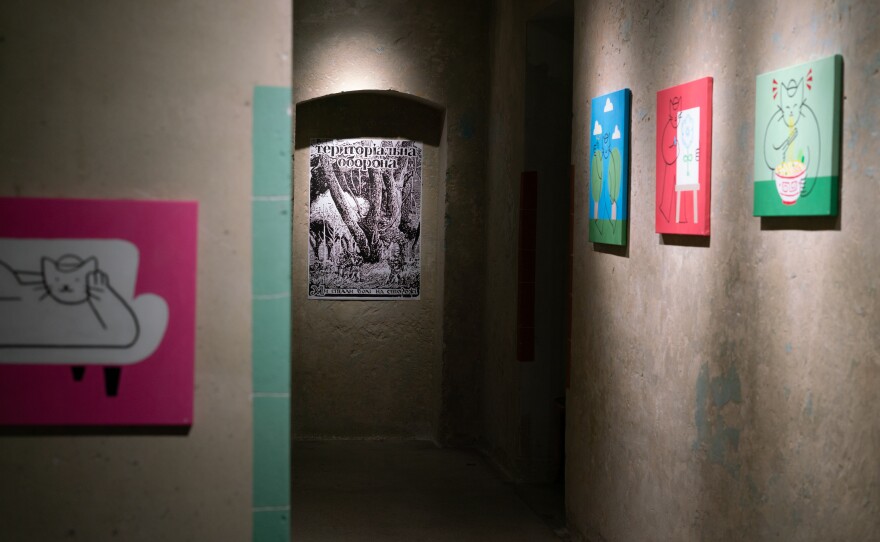A poster for the territorial defense forces hangs in Lviv Municipal Arts Center among other artwork.