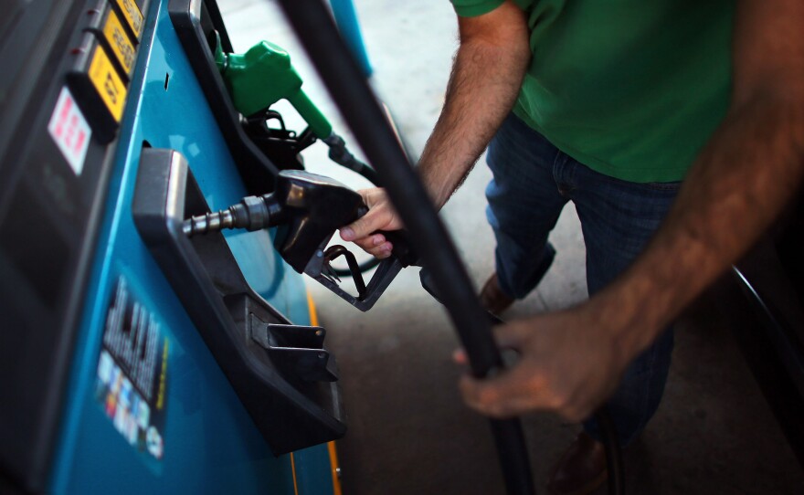 A consumer pumps gas. 