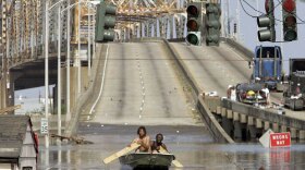 Two men paddle in high water after Hurricane Katrina devastated the area, August 31, 2005, in New Orleans, Louisiana.