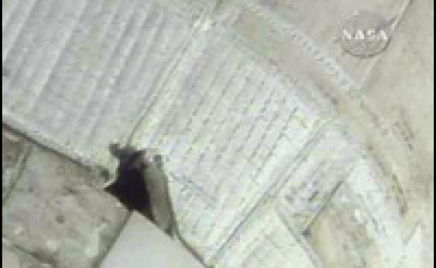 A NASA television image obtained June 10, 2007, shows a tear in the thermal blanket on the space shuttle Atlantis.