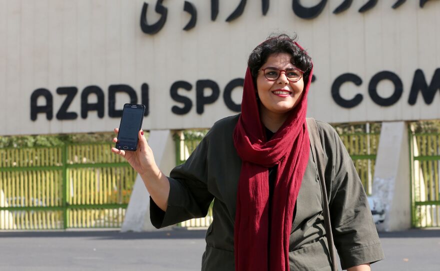 Iranian sports journalist Raha Purbakhsh shows off her ticket to attend a World Cup qualifier in front of Azadi Stadium in Tehran on Tuesday. Iran has essentially banned women from entering the stadium for decades.