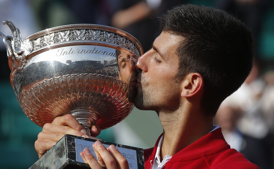 Serbia's Novak Djokovic kisses the trophy after winning the final of the French Open tennis tournament against Britain's Andy Murray in four sets 3-6, 6-1, 6-2, 6-4, at the Roland Garros stadium in Paris, Sunday.
