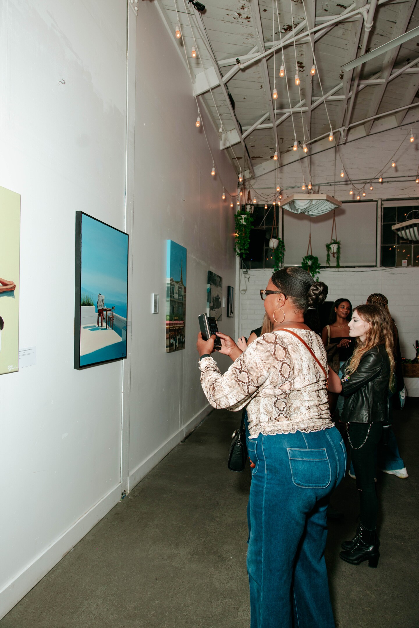 Visitors take pictures of Gillis' art at his first solo exhibition in San Diego Made Factory on Sept. 28, 2025.