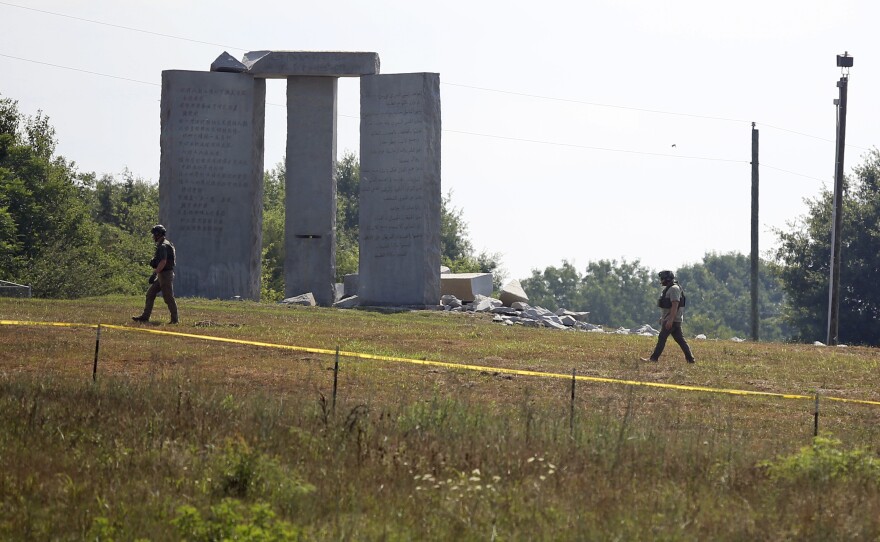 Law enforcement officials walk around the damaged Georgia Guidestones monument near Elberton, Ga., on Wednesday.