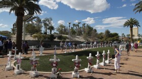 In this Sept. 30, 2018, file photo, people visit a makeshift memorial for victims of the Oct. 1, 2017, mass shooting in Las Vegas.