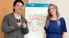 Sign painter and content creator Koy Sun, left, and The Finest host Julia Dixon Evans pose with a drawing Koy created while waiting backstage before KPBS Podcasts Live: The Art of Protest on July 12, 2026.