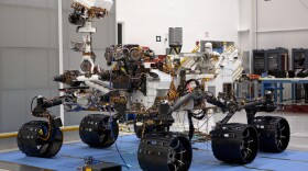 In the Payload Hazardous Servicing Facility at NASA's Kennedy Space Center in Florida, the robotic arm of the Mars Science Laboratory (MSL) rover, Curiosity, has been stowed against the body of the spacecraft.