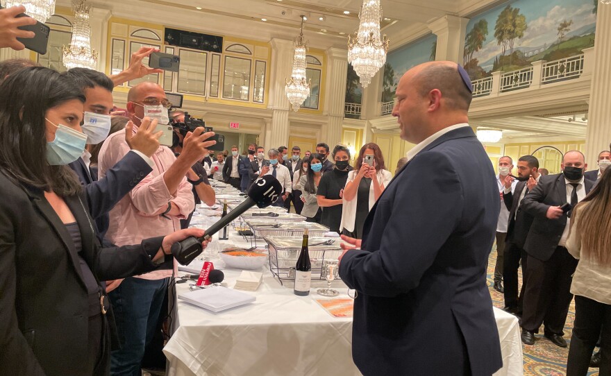 Israeli Prime Minister Naftali Bennett speaking with aides and traveling press before the start of the Jewish sabbath.