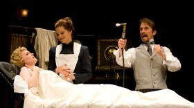 A scene from "In the Next Room or the vibrator play" at San Diego Rep. Willow Geer as Mrs. Daldry, Lisel Gorell-Getz as Annie, Francis Gercke as Dr. Givings (holding the female vibrator). 

