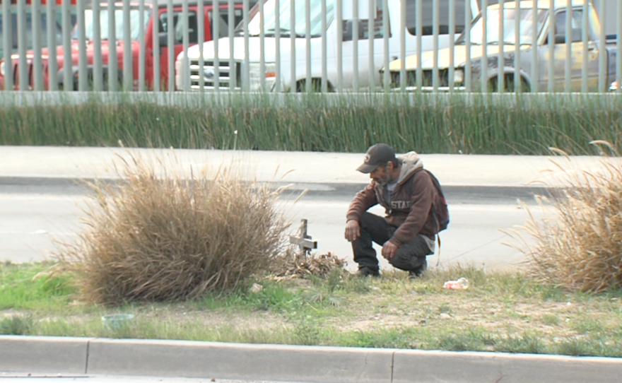 Jose Alberto Zavala, known as Chapo, kneels before the cross he erected in memory of a friend killed in a car accident, Jan. 15, 2016. 