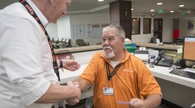 Robert Tierney Jr., right, a patient registration specialist at Mercy Medical Center, who lost his home in the recent fires, receives a message from Dignity Health North State's spokesman Mike Mangas, left, that a citizen wants to offer him a place to live in Redding, Calif., Thursday, Aug. 2, 2018. 