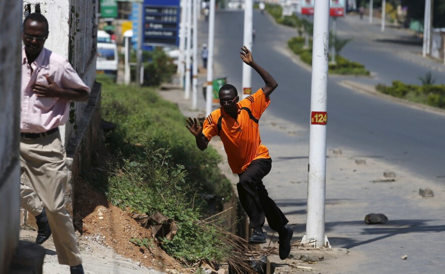 Men run for cover after they hear gunfire in a street in Bujumbura, Burundi on Thursday, a day after an army general declared he'd toppled the country's president in a coup.