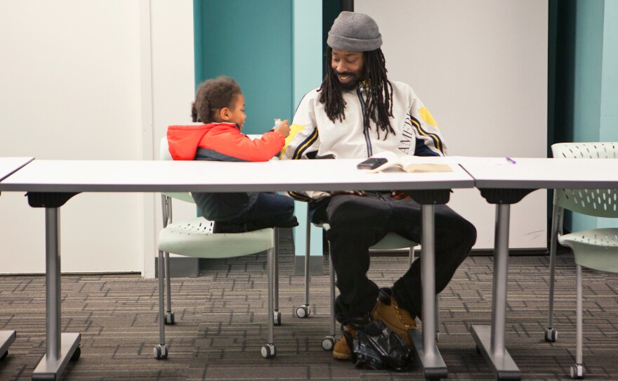 Michael Cornish, right, and his son Naeem, wait for a Responsible Fatherhood meeting to begin at the Center for Urban Families on Nov. 11. The weekly meetings are part of a program for parents to reduce their child support debt.