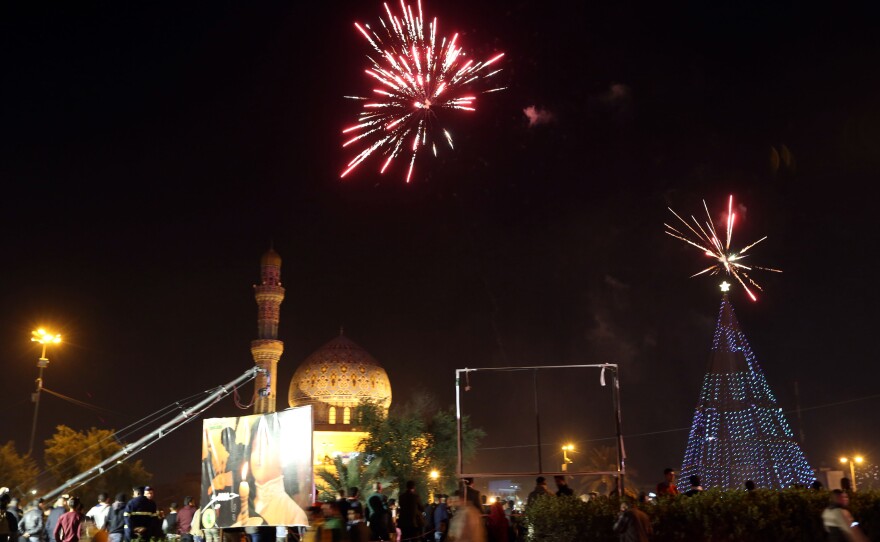 Iraqi crowds cheer as the countdown and fireworks begin during a New Year's Day celebration at Firdos Square in Baghdad on Wednesday.