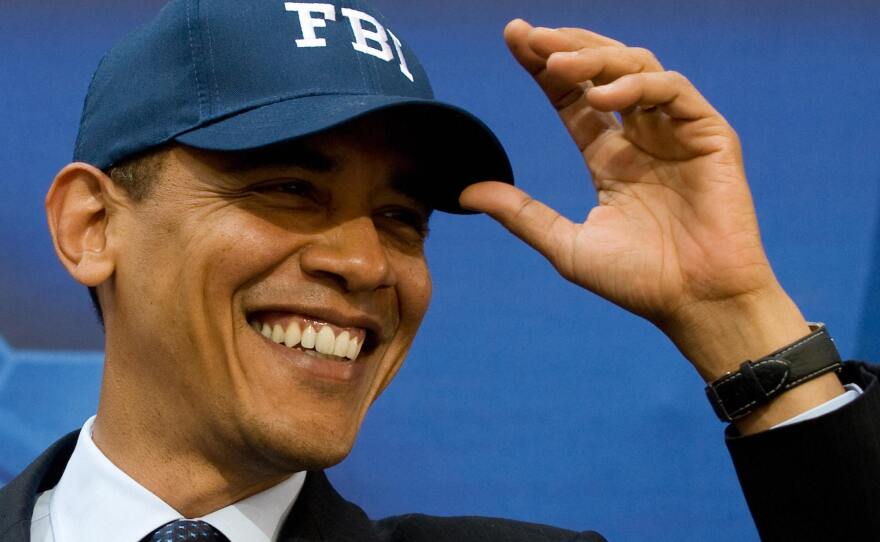 Then-President Barack Obama wears an FBI hat given to him by then-FBI Director Robert Mueller before speaking to employees at FBI Headquarters in Washington, D.C., in April 2009.