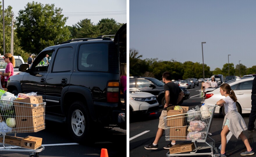 Volunteers with the nonprofit groups One Generation Away and Second Harvest Food Bank of Middle Tennessee load up cars with shopping carts full of donated food.